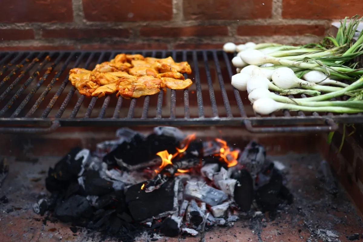 Pollo y cebollitas en el asador al carbón